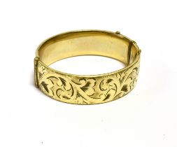 9CT GOLD METAL CORE BANGLE 18.7mm wide with foliate and scroll engraving to front, stamped ''1/5th