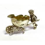 CONTINENTAL SILVER PLATED SALT In the form of an Amorini pushing an embossed barrow with parcel gilt