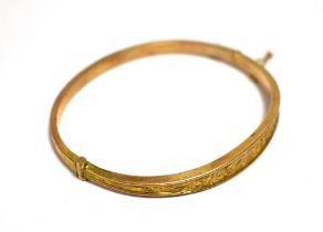 VICTORIAN ROSE GOLD BANGLE 9ct gold, oval in shape, with a scroll and foliate engraved front, push