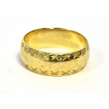 9CT GOLD WEDDING BAND 7.3mm wide with faceted bright cut decoration to sides, ring size R.