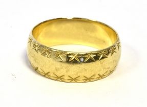 9CT GOLD WEDDING BAND 7.3mm wide with faceted bright cut decoration to sides, ring size R.