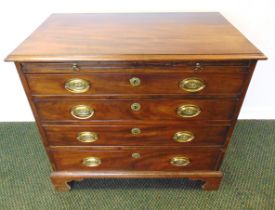 A GEORGE III MAHOGANY CHEST OF DRAWERS with a brushing slide above four graduated long drawers