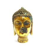 A BRASS BUDDHA HEAD the base with a cast seal mark, 14.25cm high. Provenance: Purchased by the