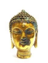 A BRASS BUDDHA HEAD the base with a cast seal mark, 14.25cm high. Provenance: Purchased by the