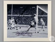 A large black and white photographic print of Sir Trevor Brooking scoring the winning goal in the 1