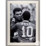 A large black and white photographic print of Pele embracing Muhammad Ali