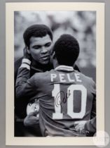 A large black and white photographic print of Pele embracing Muhammad Ali