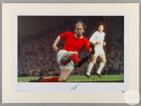 A large colour photographic print of Sir Bobby Charlton playing for Manchester United.