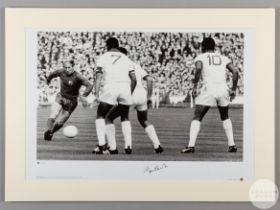 A large black and white photographic print of Sir Bobby Charlton playing against Benfica in the 1968