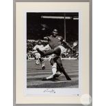 A large black and white photographic print of Eusebio playing for Benfica against AC Milan in the 1