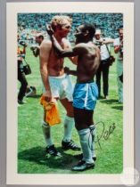 A large colour photographic print of Pele exchanging shirts with Bobby Moore following Brazil's def