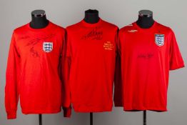 A red replica England shirt autographed by George Cohen, Jackie Charlton, Ray Wilson and Alan Ball