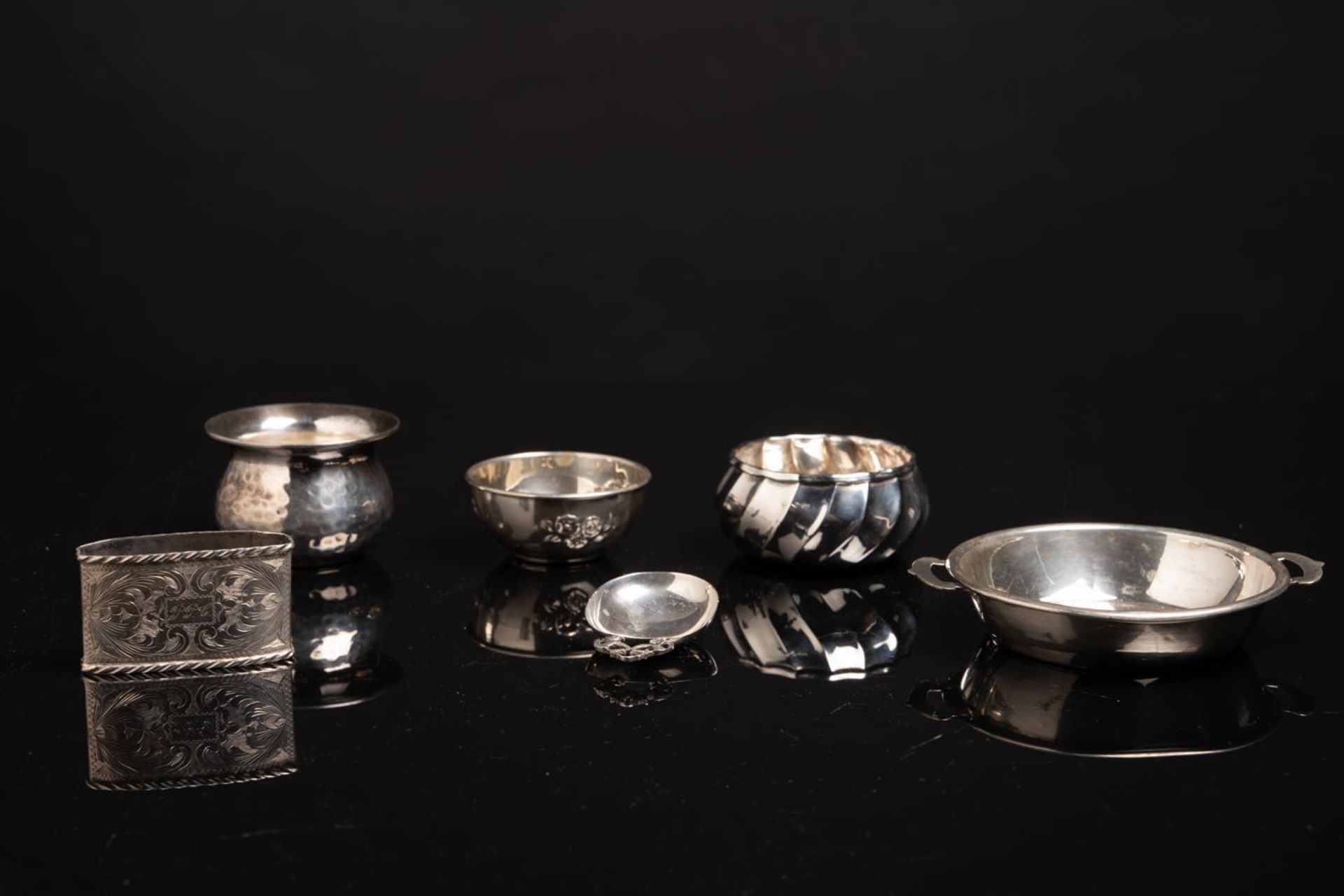 Lotto di sei oggetti in argento, XX secolo. Composto da: Cucchiaio in argento con presa a forma di
