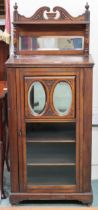 An early 20th century music cabinet with mirror backed superstructure over single glazed door with