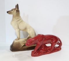 A French pottery model of a lion, glazed red together with a seated pottery dog, after Francois