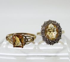 A 9ct gold citrine ring, size O1/2, together with a further citrine ring with cubic zircona size