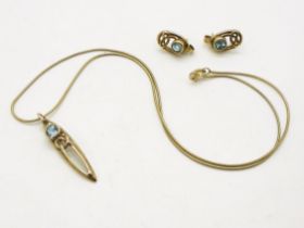 A 9ct gold celtic knot and blue topaz pendant and earring set by Ortak. Weight 5.7gms Condition