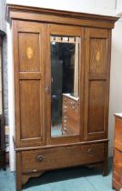 A late Victorian oak wardrobe with single mirrored door over long drawer on bracket feet, 199cm high