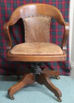 A 20th century beech framed revolving desk chair with brown Rexine upholstered backrest and seat,