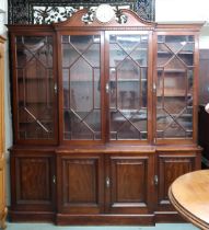 A late Victorian/Edwardian mahogany breakfront bookcase with brass bulkhead clock mounted to