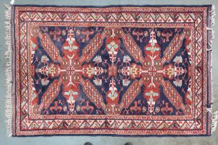 A dark blue ground Caucasian rug with pair of red medallions with multicoloured borders, 197cm