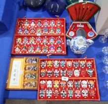 A cased of Chinese reverse painted snuff bottles, Chinese opera mask wall hangings, a calligraphy