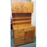 A 20th century pine estate built kitchen cabinet with pair of cabinet doors over open plate rack