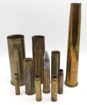An inert artillery round, together with a selection of brass shell casings, including a WW1 Trench