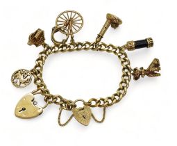 A 9ct gold charm bracelet with eight attached gold and yellow metal charms, to include a vial of