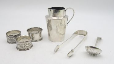 A collection of silver including a silver cream jug, by Charles Edwards, London, silver napkin