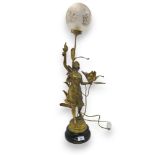 After E Rousseau, a gilded spelter lamp modelled as a maiden holding a flower in one hand and a