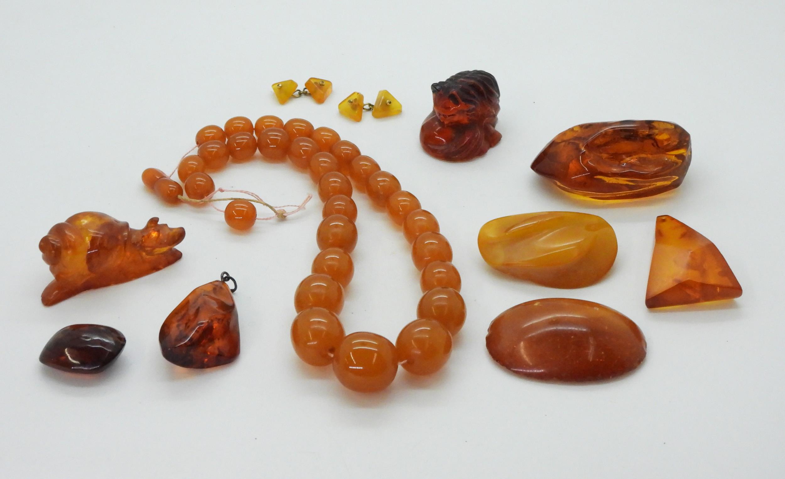 A collection of amber coloured items to include, a signed cat inro, a carved snail, amber specimens, - Image 2 of 16