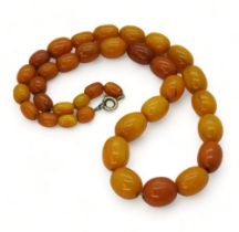 A string of yellow and orange amber coloured beads, largest bead approx 11mm x 13.6gms, overall