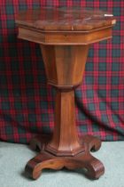 A Victorian mahogany trumpet form sewing table with octagonal hinged top concealing fitted interior,