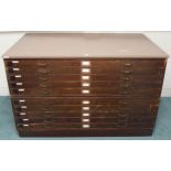 A 20th century pitch pine plan chest with painted top over ten narrow folio drawers on plinth