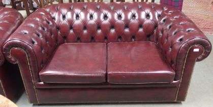 A 20th century burgundy leather buttonback upholstered two seater Chesterfield style club sofa, 73cm