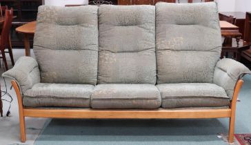 A contemporary elm and beech framed Ercol three seater settee with green foliate upholstery, 97cm
