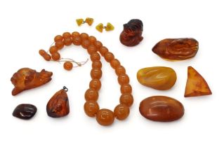 A collection of amber coloured items to include, a signed cat inro, a carved snail, amber specimens,