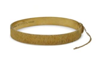 A 9ct gold retro bangle made by Nymph, London hallmarks for 1970, inner diameter 5.7cm, weight 16.