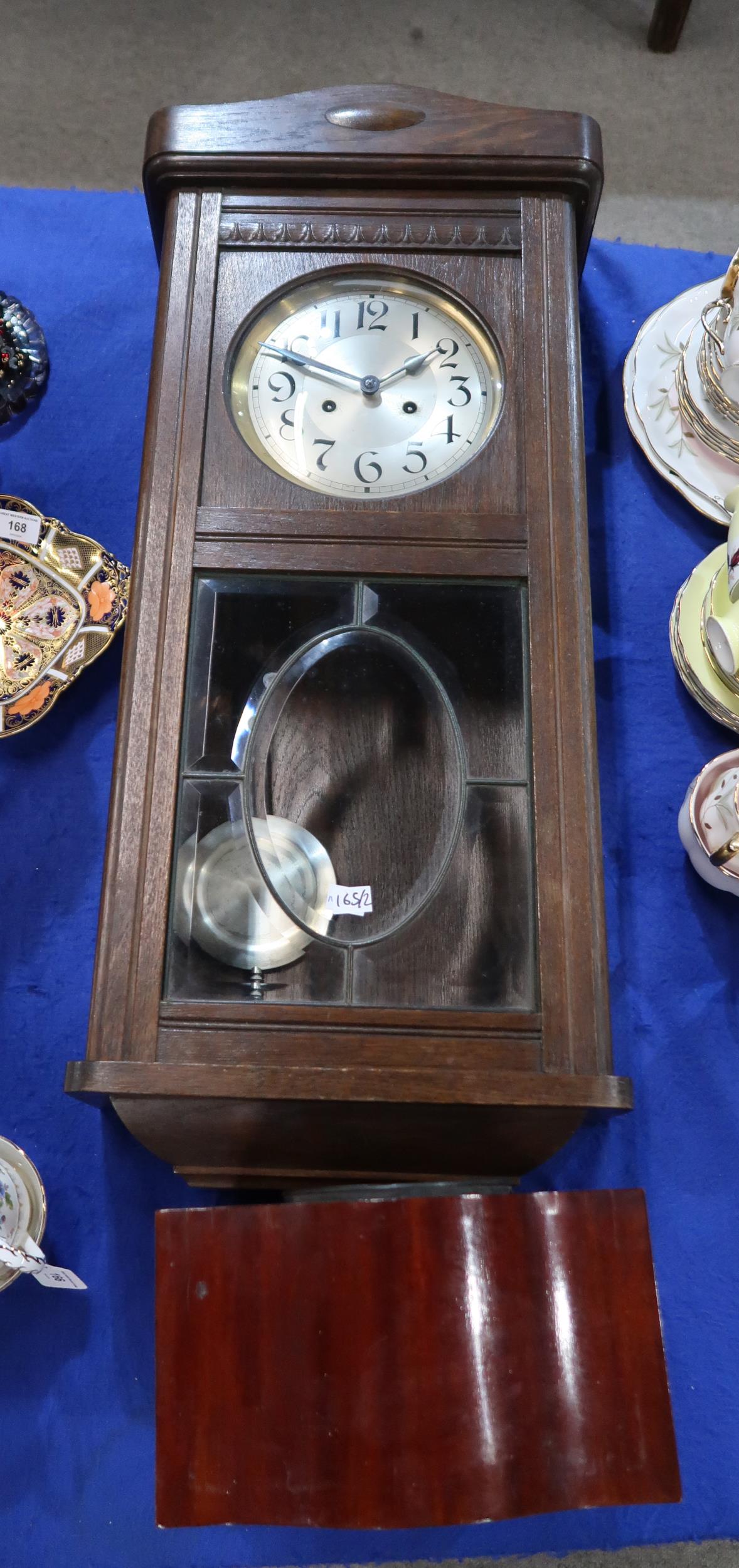 A wooden mantle clock together with a wall clock Condition Report:Available upon request