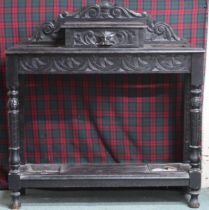 An early 20th century carved ebonised umbrella stand with single drawer flaked by umbrella holders