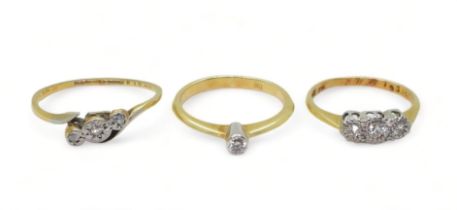 Three 18ct diamond rings, a 0.06ct solitaire size K, a illusion set three stone, size J, and a (