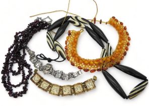 A multi strand garnet necklace, a carved antler bracelet, a white metal Egyptian themed bracelet and