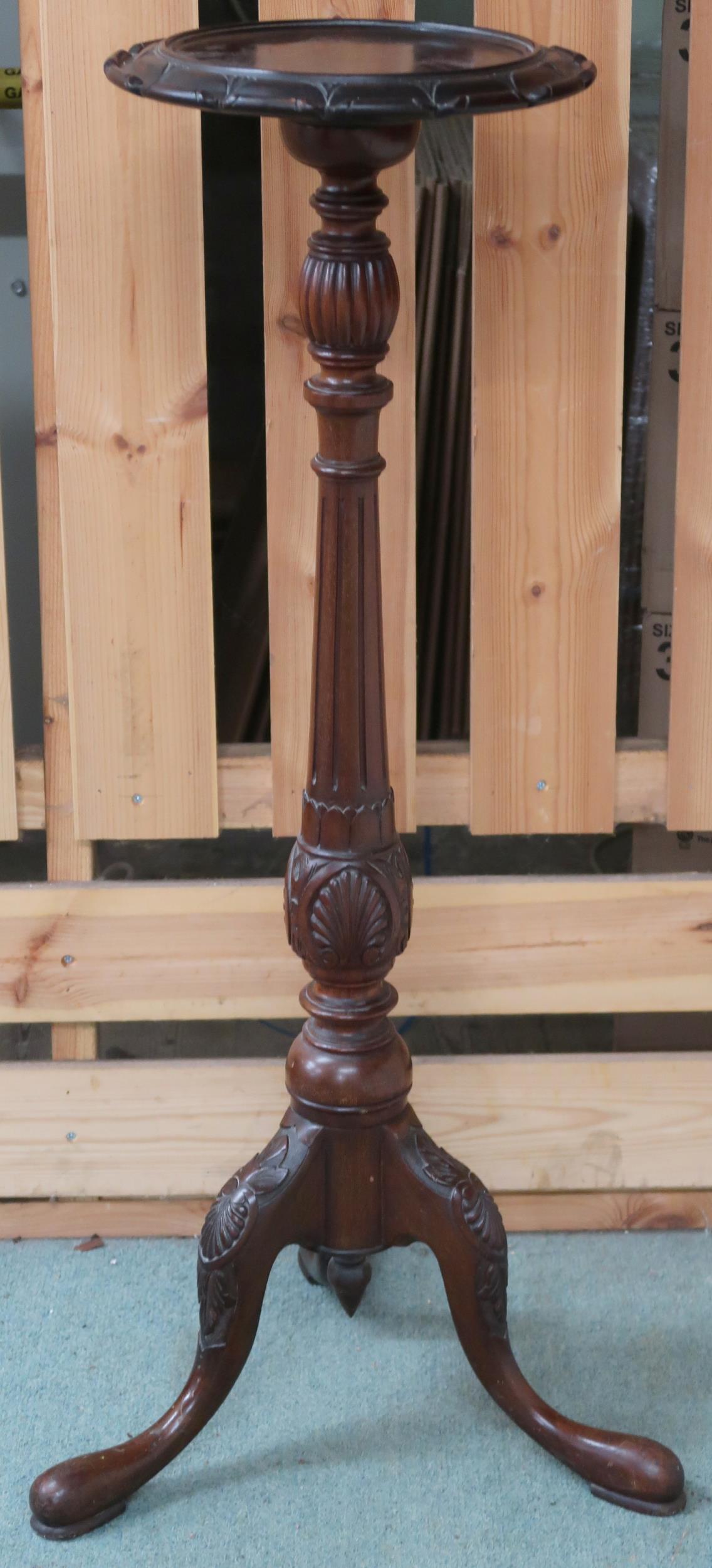 A 20th century mahogany jardiniere stand with carved circular top on turned column terminating in