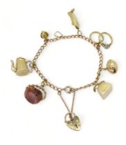 A 9ct gold charm bracelet with seven attached 9ct gold and yellow metal charms to include a speed