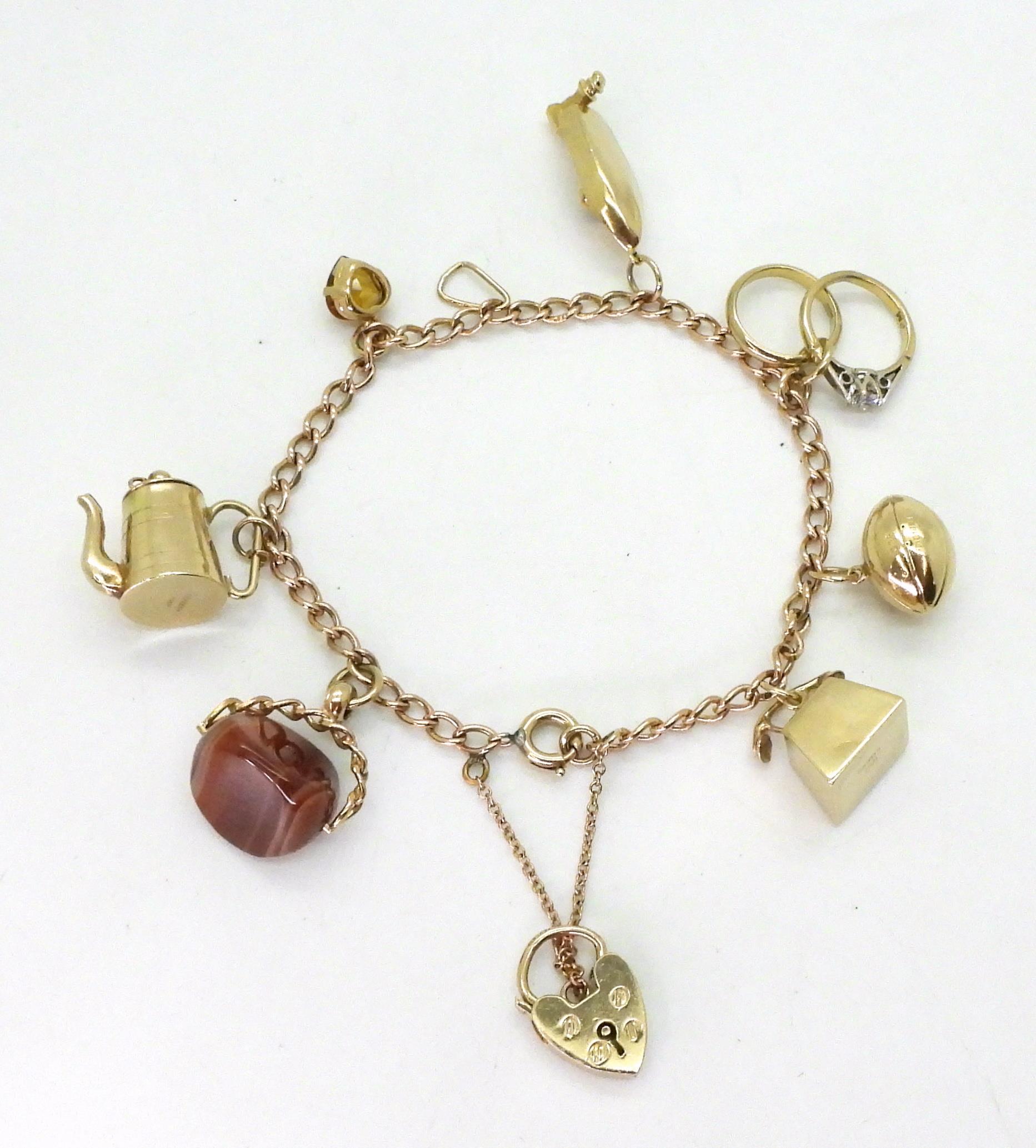 A 9ct gold charm bracelet with seven attached 9ct gold and yellow metal charms to include a speed - Image 2 of 3