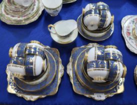 A Paragon fine bone china teaset decorated with a band of gilt peacocks on a blue ground, pattern