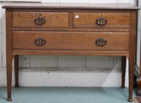 An early 20th century oak dressing chest with two short over one long drawers with stylized copper