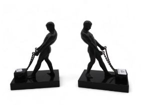 A pair of Art Deco style bookends, each modelled as a man in a loin cloth pulling a block with