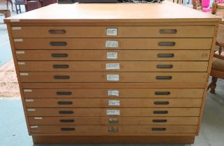 A 20th century pine plan chest with ten shallow drawers flanked by panelled sides, 92cm high x 122cm